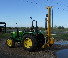 Anothe view of the Model 40 fence post driver shown on a mid-size John Deere tractor.