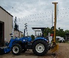 The Model 40 fence post driver on a New Holland Tractor.