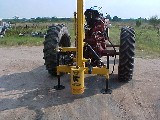 The Model 40 post driver on an old antique tractor.