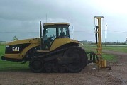 The Model 40 Black Cat Post Pounder on a huge caterpillar tractor.